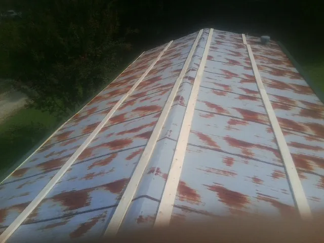 Rusted metal roof panels with new wood purlins before replacement — Storm Damage Roof Repair in Riverdale by Roofing Brothers