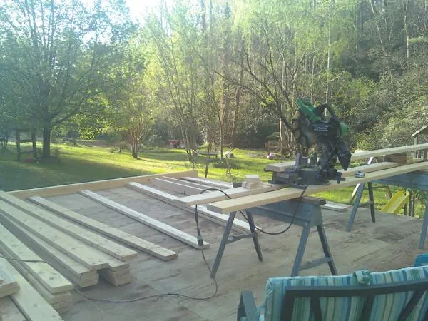 Miter saw and framing lumber on a deck under construction in Riverdale
